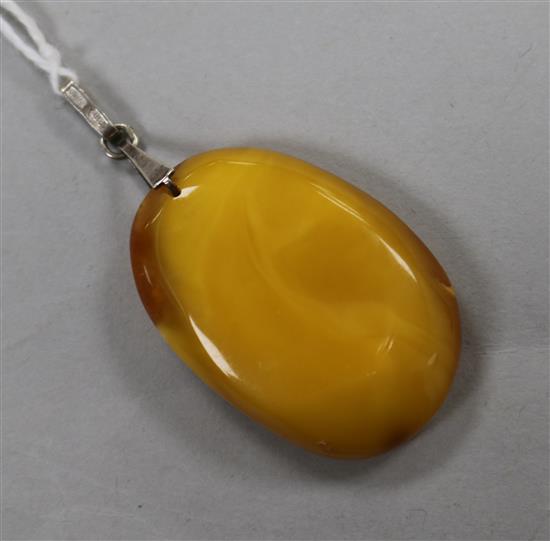 A raw amber oval pendant, gross weight 7 grams, 38mm.